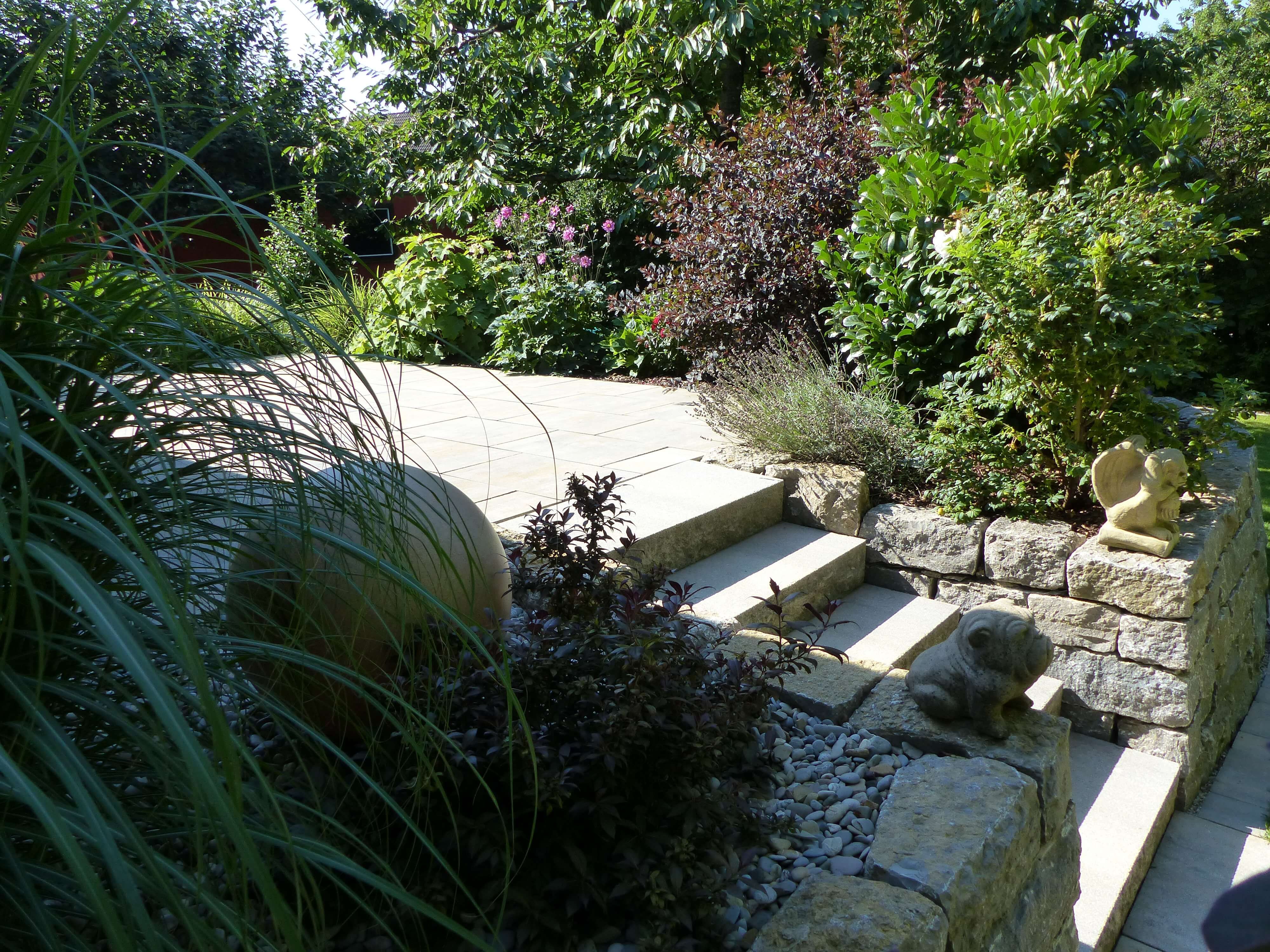 Gepflasterte Gartenterasse mit Treppe