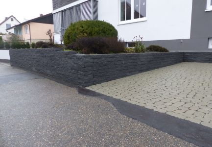Moderne Steinmauer an Parkplatzzufahrt